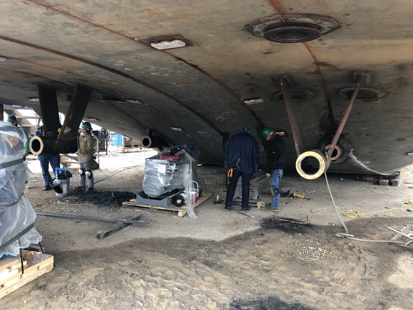 Crew performing structural work beneath a hull